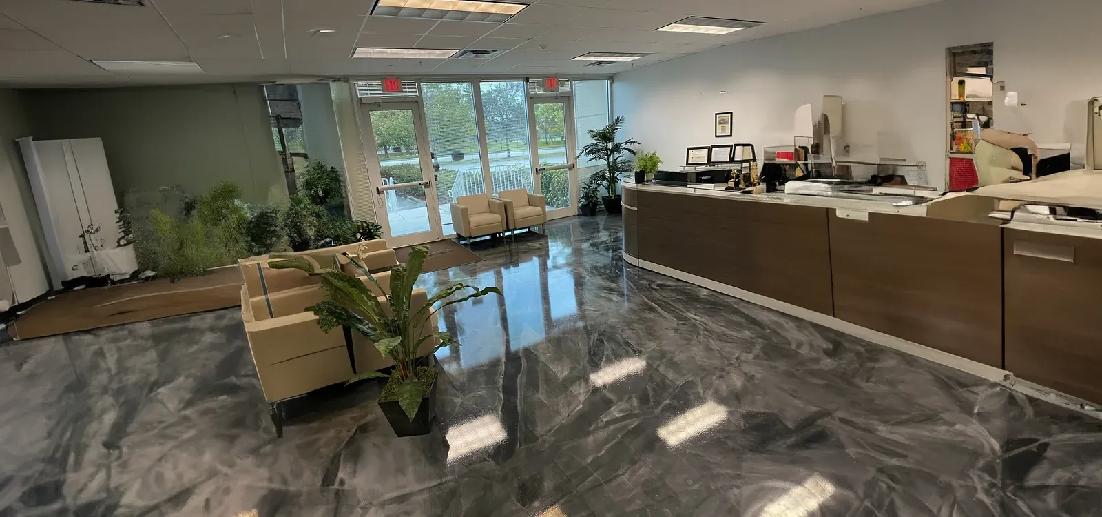 Commercial hall with a mirror-black high-gloss epoxy floor and white structural columns